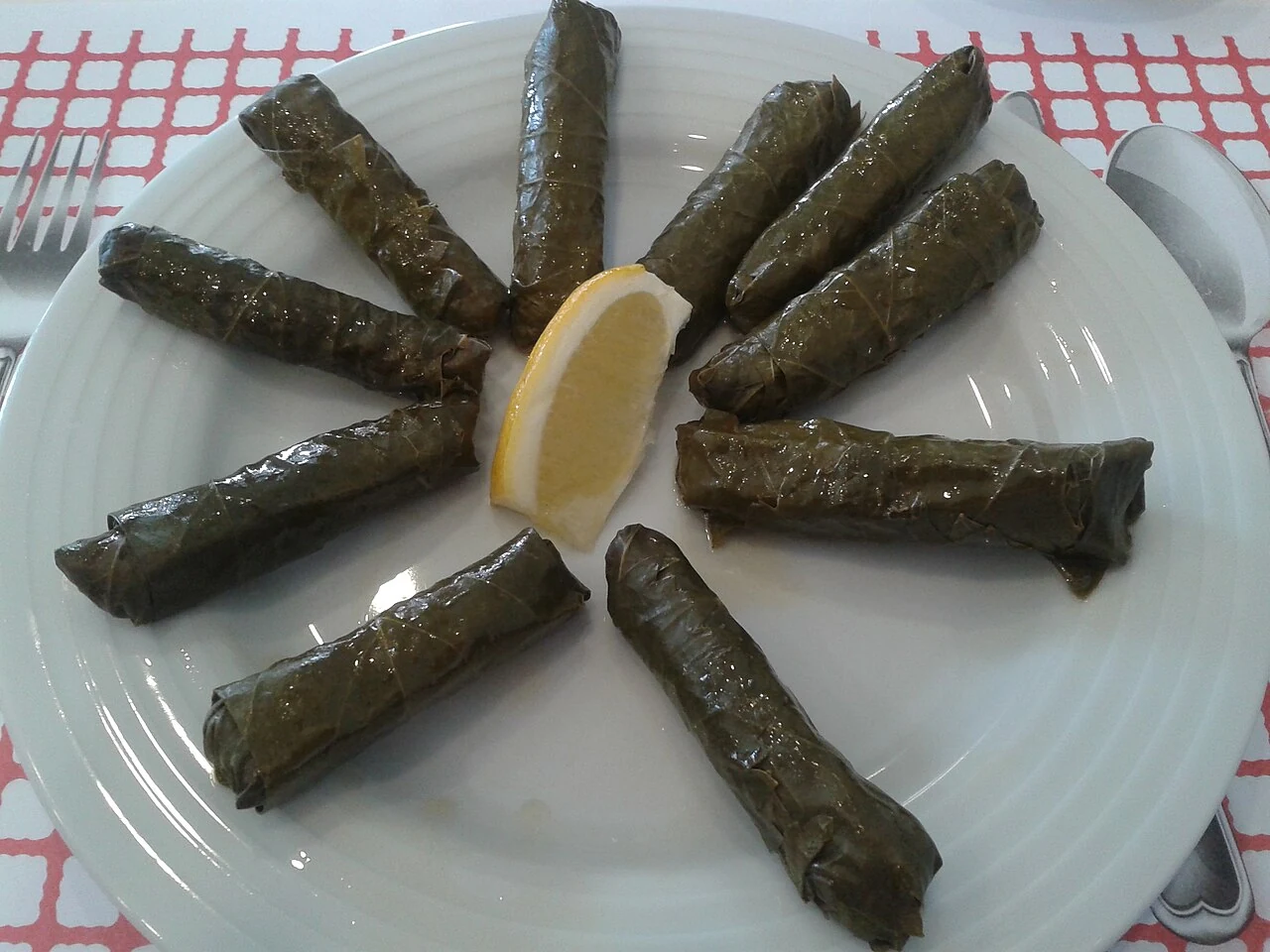 Limonla servis edilen zeytinyağlı yaprak sarma.